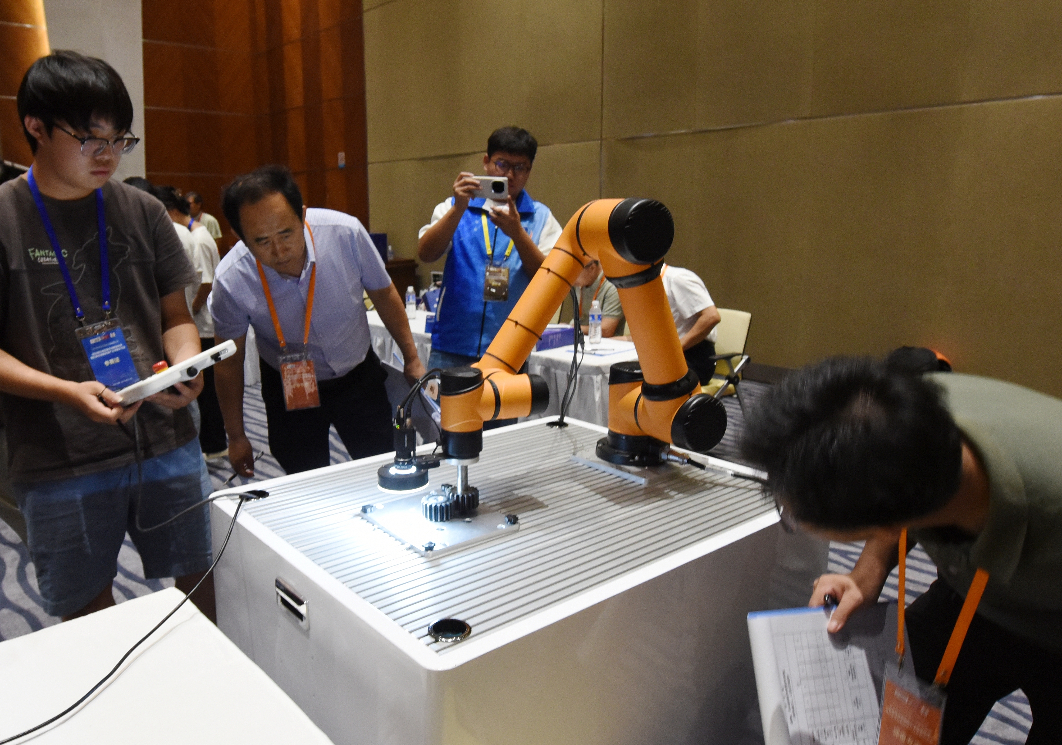 2025年中國大學(xué)生機(jī)械工程創(chuàng)新創(chuàng)意大賽智能精密裝配賽京津冀魯聯(lián)賽現(xiàn)場，評委對參賽選手進(jìn)行實(shí)操調(diào)試評比。